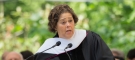 portrait of Anna Deveare Smith speaking at a podium in graduation robes